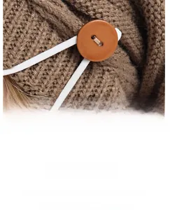 Détail macro du bonnet en maille épaisse avec bouton en bois pour attacher un masque
