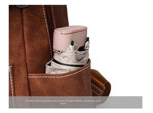 Detail of brown textured backpack showing a functional side pocket with a folding umbrella