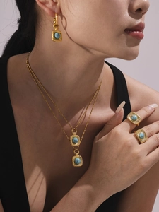 Details eines vergoldeten Schmucksets mit Türkissteinen an einem weiblichen Model