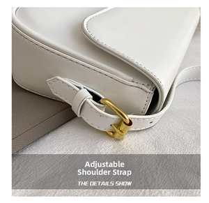 Detail shot of the adjustable white leather shoulder strap with gold metal buckle hardware