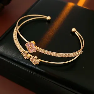 Double-layer gold clover bangle with pink gemstone and zircon flower accents
