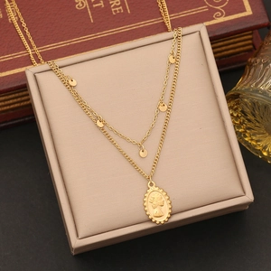 Double-layered gold necklace with classic coin pendant and discs on jewelry case
