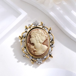 Vintage relief portrait brooch with sparkling rhinestones in a gold metal frame