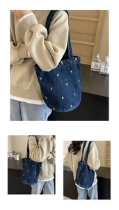Detailansicht bunter Tulpenstickerei auf einer dunkelblauen Denim-Beuteltasche für Damen