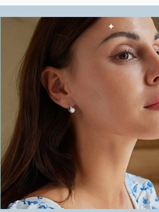Close-up of a sterling silver huggie hoop earring with a round-cut cubic zirconia stone