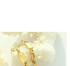 Macro detail of gold-plated chain link earrings featuring a rectangular metal pendant