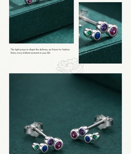 Macro detail of S925 sterling silver studs with colorful rainbow stones on dark background