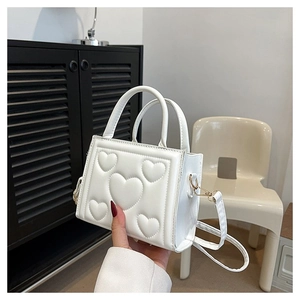 Vue détaillée du sac à main blanc avec gaufrage en cœur et bandoulière amovible