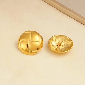 Detailed macro view of gold round earrings featuring an intricate woven metal texture
