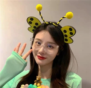 Detail of a child wearing a cute yellow honeybee antenna headband for costume parties