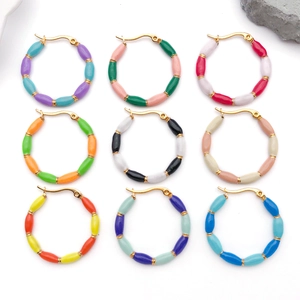 Macro view of nine colorful enamel bamboo-style hoop earrings in gold-plated stainless steel
