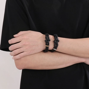 Detail of woven black leather bracelets with magnetic clasps on a male model's wrist