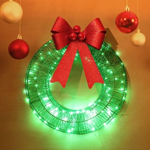 Detail of Christmas wreath with green LED lights and a sparkling red glitter bow decoration