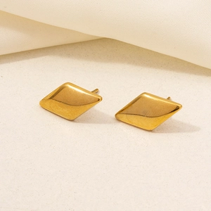 Dettaglio di orecchini a lobo geometrici a forma di diamante in acciaio inossidabile dorato