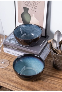 Detailed view of stackable Japanese kiln glazed ceramic bowls on rustic wooden surface