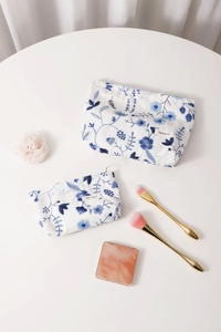Gros plan de deux trousses de toilette en coton et lin aux fleurs brodées bleues