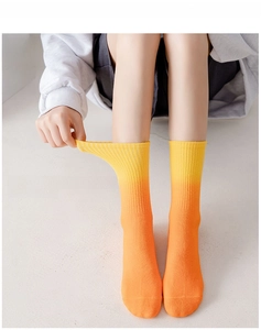 Detailed view of yellow and orange gradient crew socks showing high elasticity and soft knit texture