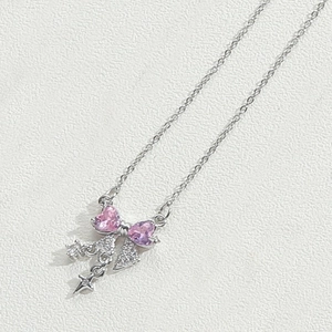 Détail du collier noeud en argent avec cœurs roses et pendentif petite étoile