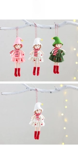 Close-up of handmade Christmas elf ornaments with felt hats and striped scarves on branches