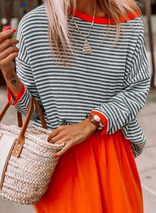 Détail d'un pull rayé gris et blanc avec col orange et sac à main assorti élégant