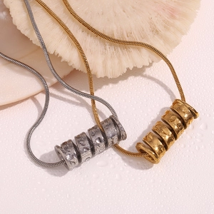 Detail of 18K gold and silver spiral spring pendants on sleek snake chains