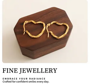 Macro shot of gold heart-shaped hoop earrings with a twisted metal texture detail