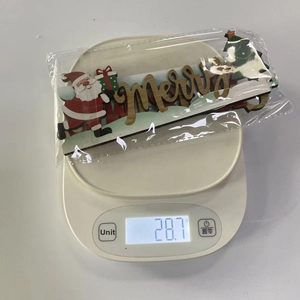 Detail showing Santa Claus wooden door corner ornament weight in packaging at 28.7g