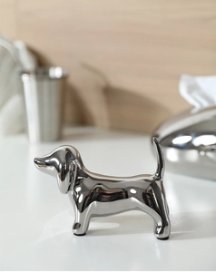 Close-up of silver plated dachshund statue with a reflective polished metallic surface