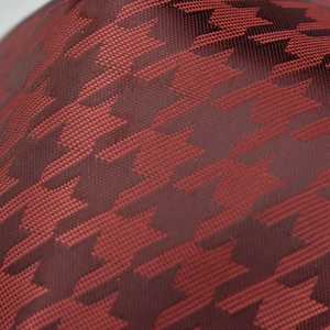 Macro shot of dark red houndstooth jacquard fabric texture on a fashion baseball cap