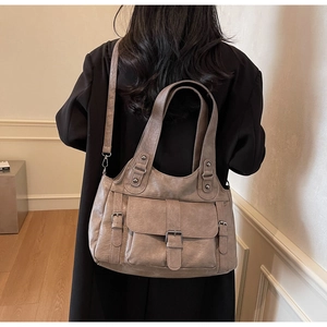 Model showcasing a vintage khaki large capacity tote bag with front and side flap pockets