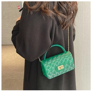 Crossbody view of a green jelly bag featuring quilted patterns and a golden chain strap