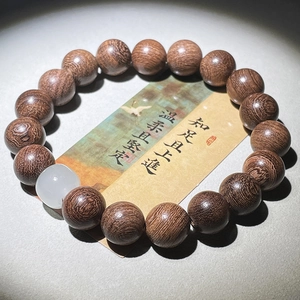 Vue macro détaillée de perles de prière en santal avec perle de jade blanc et carte zen