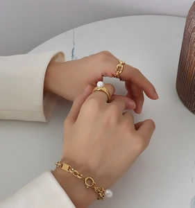 Close-up of 18k gold plated bracelet and rings set with elegant freshwater pearls
