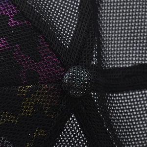 Close-up macro detail of breathable black mesh trucker cap with colorful iridescent patterns