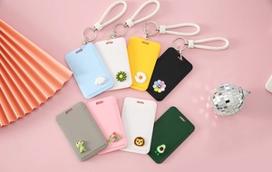 Detailed flat lay of colorful cartoon card holders with braided lanyards and pendants