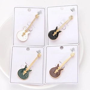 Detailed close-up of four guitar enamel pins in various colors on display cards