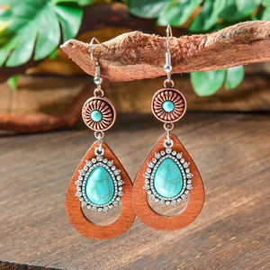 Macro shot of bohemian vintage drop earrings with turquoise stones and wooden beads details
