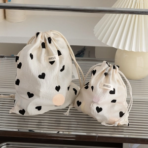 Close-up of heart print drawstring storage bags in two sizes on a modern metal tray