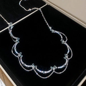 Detailed close-up of sparkling zircon butterfly pendants on an elegant silver necklace chain