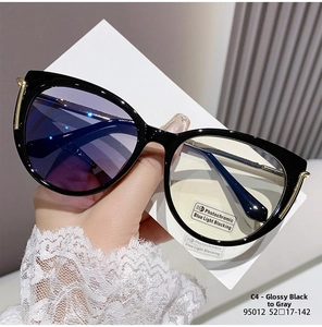 Detail of cat eye glasses with gold metal accents and photochromic blue light lenses