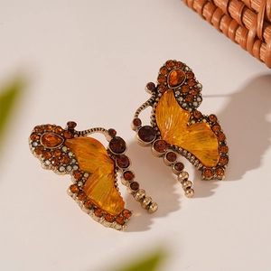 Close-up of vintage bronze butterfly earrings with amber crystals and resin wings