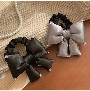 Detail of elegant black and grey satin scrunchies featuring sparkling rhinestone accents