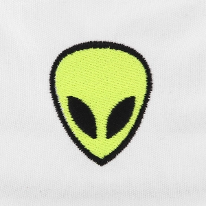 Macro detail of high-quality fluorescent green alien embroidery patch on white fabric