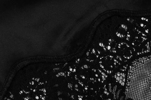 Gros plan du satin noir et de la dentelle florale pour la texture de la robe