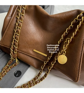 Close-up of the vintage brown leather bag with chain strap and gold hardware detail