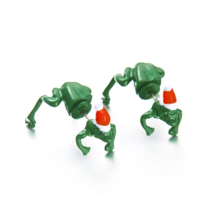 Whimsical green frog earrings wearing red and white Christmas hats on a white surface