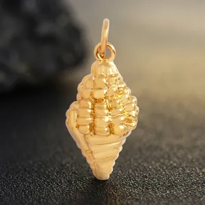 Pendentif coquillage en laiton doré montrant les textures naturelles et les dimensions