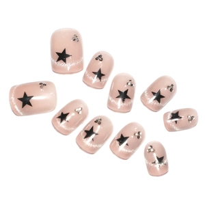 Pink cat eye press-on nails with black star accents and sparkling silver rhinestones