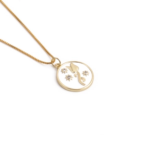 Detailed view of golden tulip flower pendant necklace with white enamel inlay and stars