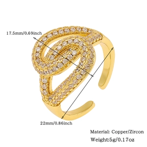 Detail of gold copper ring with twisted geometric design and inlaid zircon stones